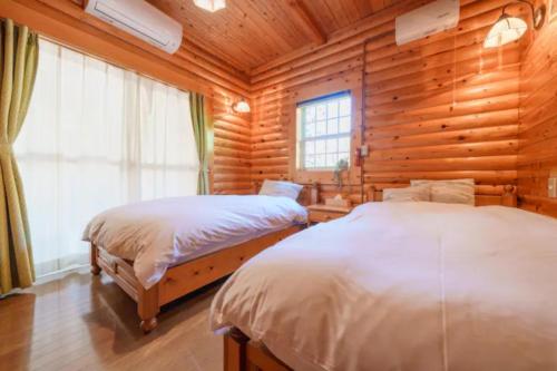 a bedroom with two beds in a log cabin at Mori no Kuni - Vacation STAY 03921v in Ōma