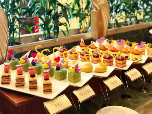 a display of different types of desserts on trays at Dongguan Richwood Garden Hotel in Dongguan