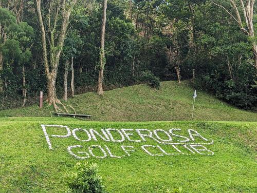a sign that says ponergy golf club in the grass at Ponderosa Golf and Resort in Puerto Galera