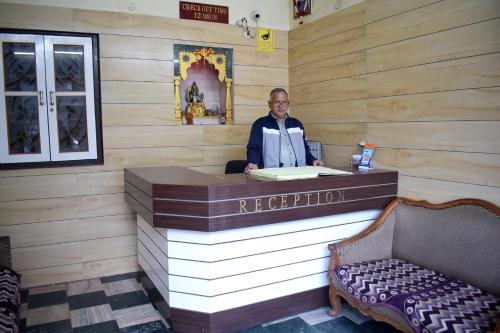a woman standing at a register in a wooden room at Hotel Golden in Haridwār