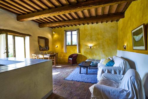 uma cozinha e sala de estar com paredes amarelas e um sofá em Podere Campalfi em Stigliano