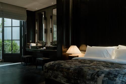 a bedroom with a bed and a bathroom with a mirror at The Six Weligama in Weligama