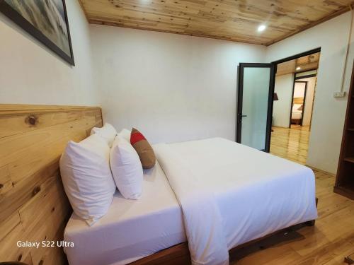 a bedroom with a bed with white sheets and pillows at SaPa Retreat Condotel in Sapa