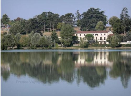 a house is reflected in the water of a lake at Charmante maison rénovée, proche lac et centre-ville in LʼIsle-Jourdain