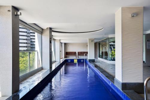 an indoor pool with blue water in a building at Swainson at Embassy in Adelaide