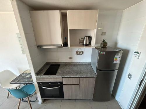 uma pequena cozinha com um lavatório e um frigorífico em Loft cómodo Iquique central em Iquique