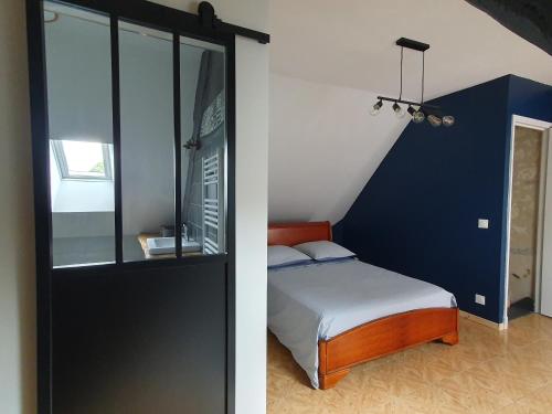 sypialnia z łóżkiem i niebieską ścianą w obiekcie Gite de la Guernouille w mieście Luçay-le-Mâle