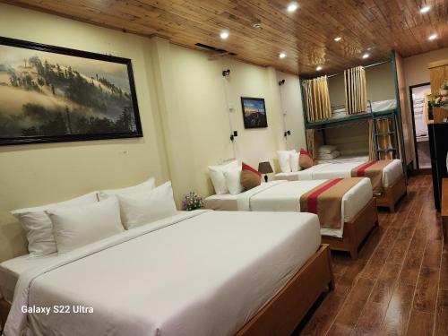 a room with two beds and a couch in it at SaPa Retreat Condotel in Sa Pa