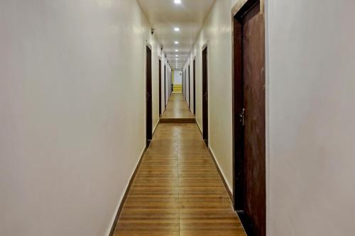 a long hallway with white walls and wooden floors at Gauri Shree Hotel in Bhopal