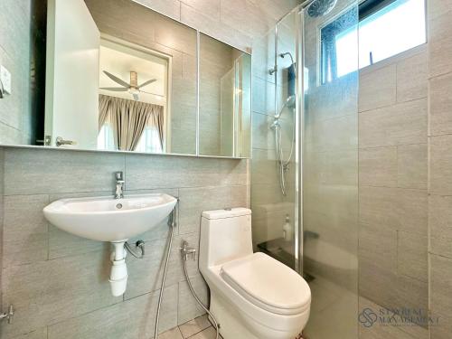 ein Badezimmer mit einem Waschbecken, einem WC und einem Spiegel in der Unterkunft Melaka Ong Kim Wee Residences by Stayrene in Malakka