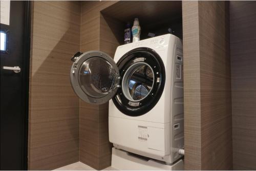 a washer and dryer in a room at ゆくれば前島ホテル in Naha