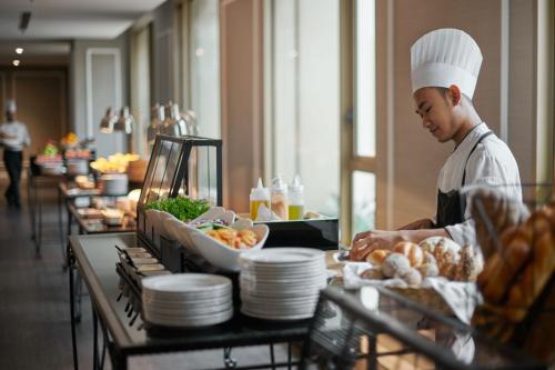 a chef preparing food at a buffet in a restaurant at JW Marriott Kuala Lumpur in Kuala Lumpur