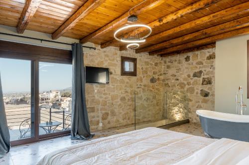 Athali villa في Krousón: غرفة نوم مع سرير وحوض استحمام وتلفزيون