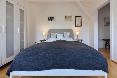 a bedroom with a large bed with two lamps at CBlue "Friedrich Franz", 500 m zum Strand, zentral in Warnemünde