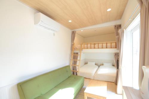 a small bedroom with a green couch and bunk beds at Mt Fuji Glamping TOURIST VILLA Kawaguchiko in Fujikawaguchiko