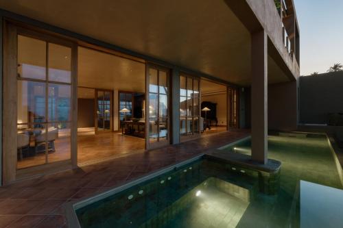 a house with a swimming pool in front of a building at The Six Weligama in Weligama