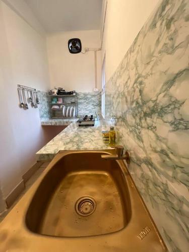 um lavatório numa cozinha com uma parede de mármore em The Divine Abode Homestay 1 em Guwahati