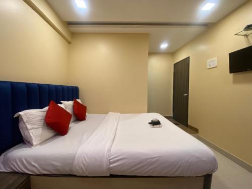 sypialnia z dużym łóżkiem z czerwonymi poduszkami w obiekcie Hotel Royal Grand - Near Mumbai International Airport w Bombaju