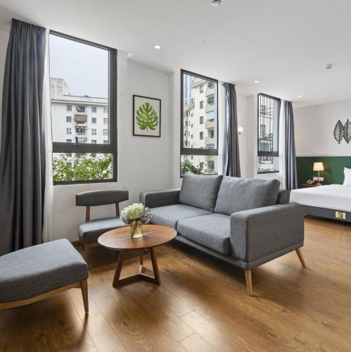 a living room with a couch and a bed at 22Land Classic Suites in Hanoi
