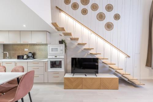 a kitchen with a staircase with a tv and a living room at Real Apartments Museum in Budapest