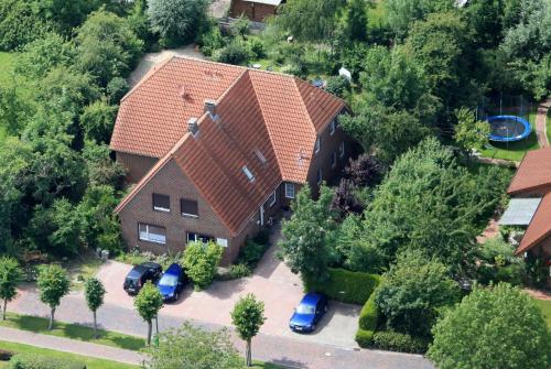 una vista aérea de una casa con coches aparcados en una entrada en Balkonwohnung Norderney, en Hooksiel