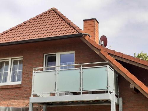 a house with a balcony on the roof at Balkonwohnung Roter Sand in Hooksiel