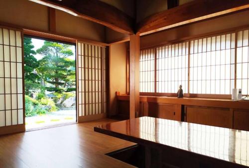 忍野村的住宿－民宿富島 Tomijima Hostel-Traditional japapnese whole house with view of mt fuji - Oshino Hakkai，大房间设有大窗户和桌子