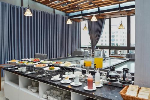 een buffet met eten en drinken op een tafel bij 22Land Classic Suites in Hanoi