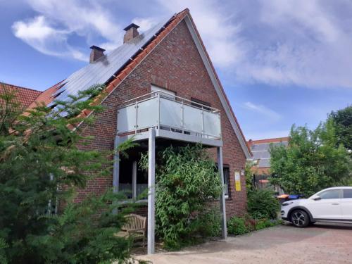 a brick house with an open window on the side of it at Helle Balkonwohnung Spiekeroog in Hooksiel