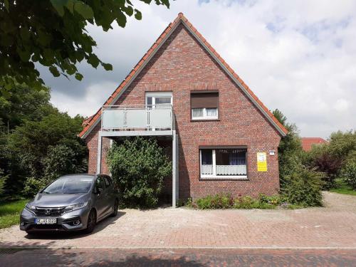 a car parked in front of a brick house at Terrassenwohnung Baltrum in Hooksiel