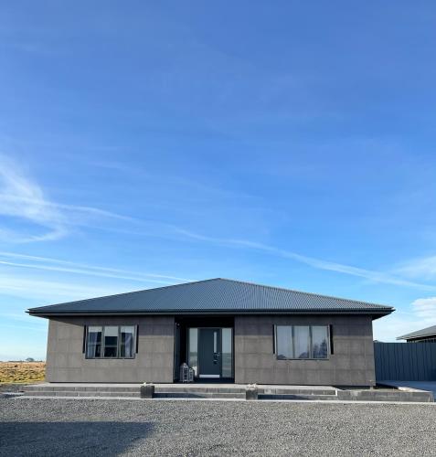 a house with a black roof on a street at Nyibaer studio apartment in Selfoss