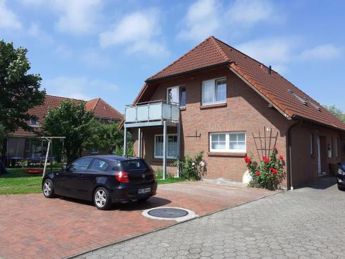 un coche negro estacionado frente a una casa en Terrassenwohnung Strandlust, en Hooksiel