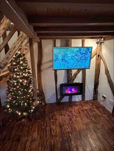 a christmas tree in a living room with a tv at Cozy Cottage with hot tub! in Cadnam