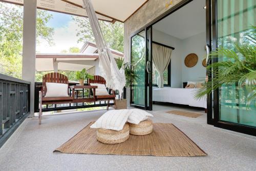 a living room with a bed and a large window at Why Nam Beach in Haad Yuan