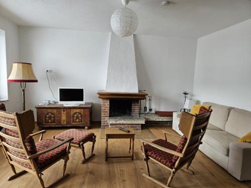 sala de estar con sofá y chimenea en Ferienhaus Birnberg, en Leogang