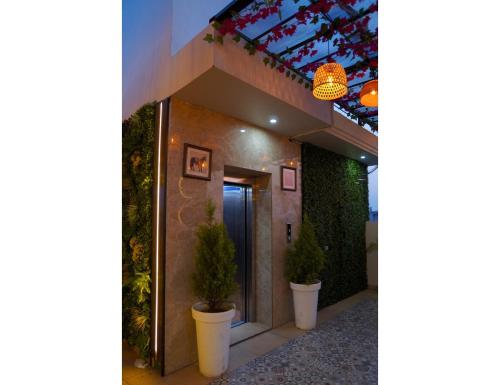 a hallway with two potted plants in front of a building at The Royal Casa Hotel, Ludhiana in Ludhiana