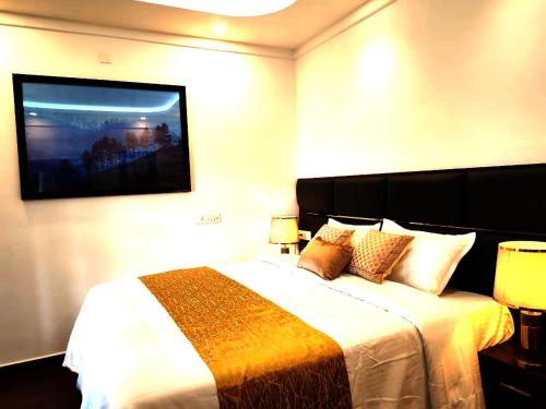 a hotel room with a bed and a tv on the wall at Tea & Sky Munnar in Munnar