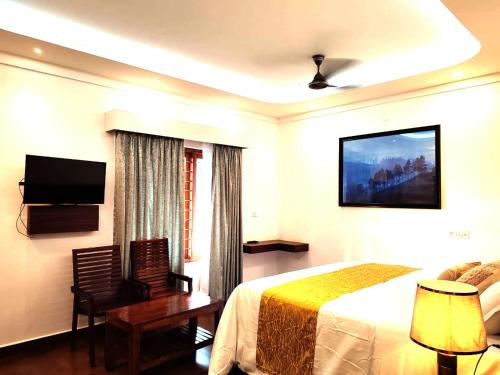 a hotel room with a bed and a flat screen tv at Tea & Sky Munnar in Munnar