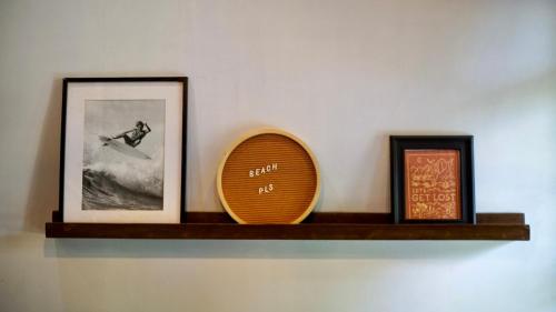 a shelf with a picture and a surfboard and a mirror at Happiness Villas in El Nido