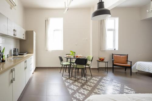 a kitchen and dining room with a table and chairs at The Printhouse - Downtown Boutique Apartments by Sea N' Rent in Haifa