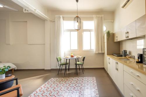 a kitchen with a table and chairs and a window at The Printhouse - Downtown Boutique Apartments by Sea N' Rent in Haifa