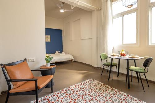 a living room with a table and chairs at The Printhouse - Downtown Boutique Apartments by Sea N' Rent in Haifa