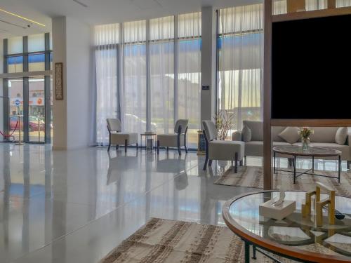 a living room with a tv and a table and chairs at فندق ارجان بارك العزيزية Arjan Park Hotel in Riyadh
