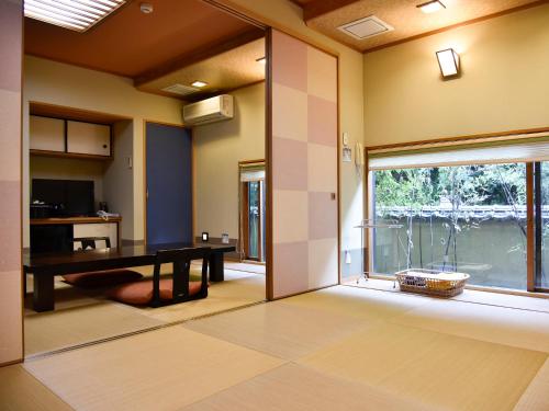 a dining room with a table and a large window at Oyado Yumechidori in Saga