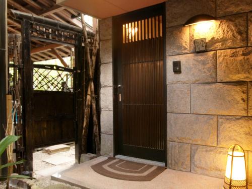 an open door in a room with a stone wall at Oyado Yumechidori in Saga