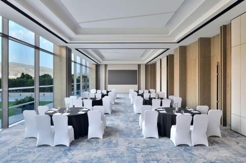 a conference room with white tables and white chairs at Marriott Executive Apartments Navi Mumbai in Navi Mumbai