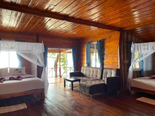 a living room with a couch and a bed and window at Kohjum Relax Beach in Ko Jum