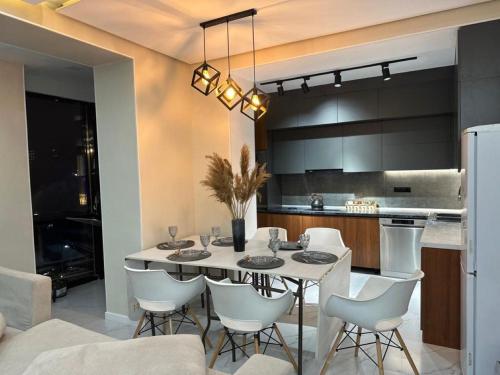 een keuken en eetkamer met een witte tafel en stoelen bij ЖК Falcon City in Alma-Ata