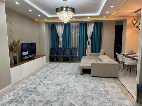 a living room with a couch and a tv and a table at ЖК Falcon City in Almaty