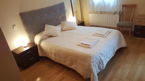 1 dormitorio con 1 cama grande y 2 toallas. en Villa Yolita, en Sepúlveda